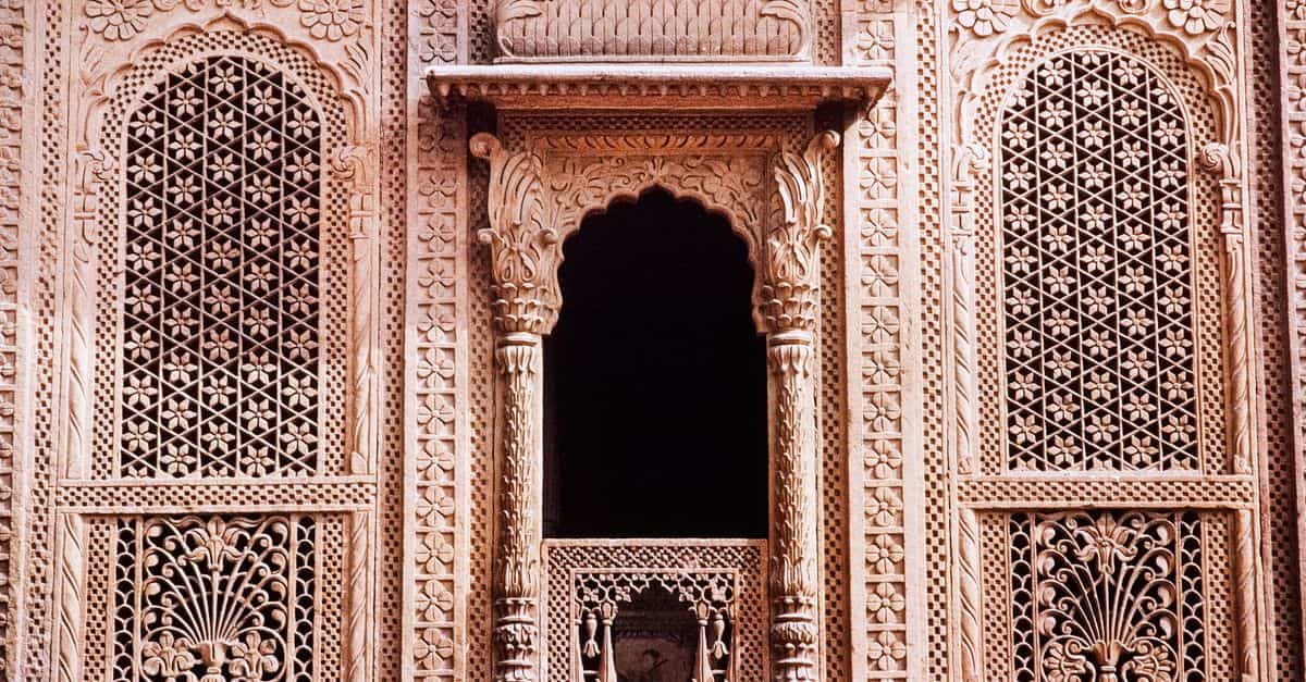 Close-up of traditional Indian lattice window showcasing fine stone carvings and intricate architecture.