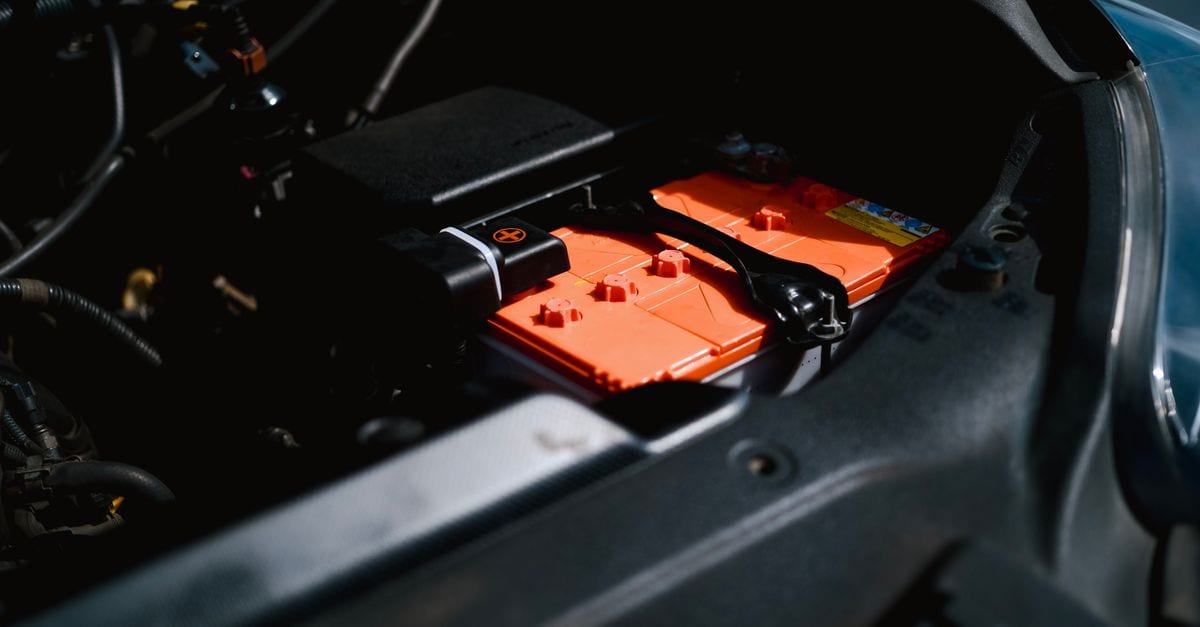 Detailed view of an electric car battery inside a vehicle's engine compartment, highlighting sustainable technology.