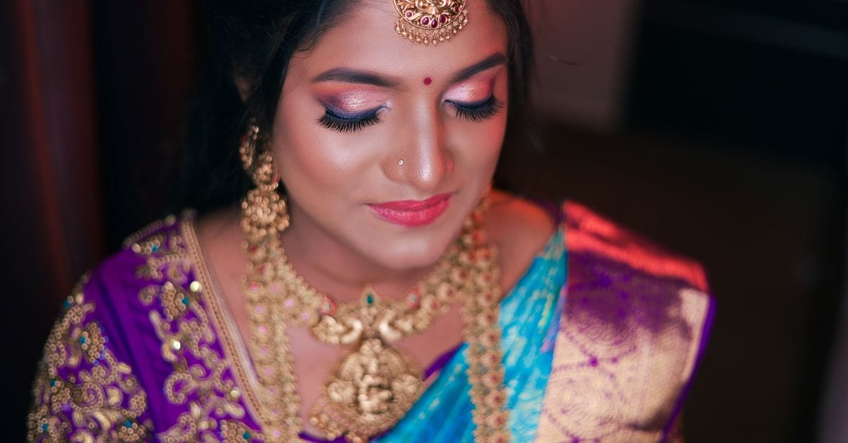 Close-up of an Indian bride wearing vibrant traditional attire and jewelry, exuding cultural elegance.