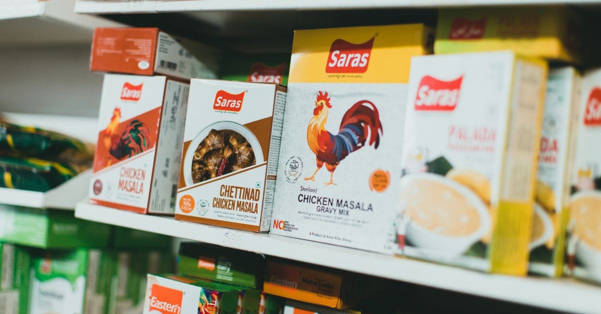 Assortment of Indian spice mixes on a grocery store shelf, featuring colorful packaging.