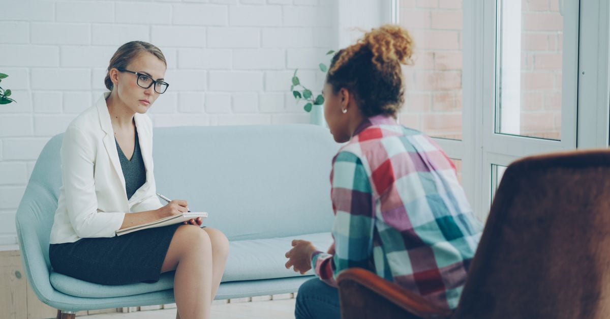 A therapist listens attentively during a private counseling session.