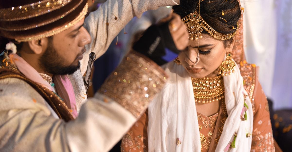 Close-up of traditional Indian wedding ceremony with bride and groom exchanging rituals.